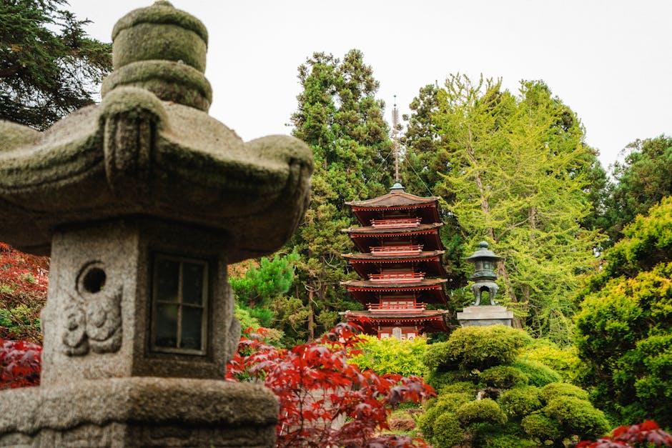 A peaceful scene of a Japanese pagoda surrounded by lush greenery and traditional stone lanterns.